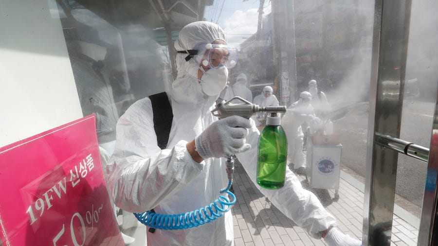 A worker wearing protective gears sprays disinfectant as a precaution against the coronavirus at a shopping street in Seoul, South Korea, Thursday, Feb. 27, 2020. The new illness persists in the worst-hit areas and spreads beyond borders. (AP Photo/Ahn Young-joon)