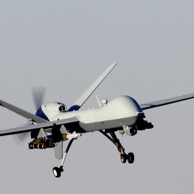 In this file photo provided by the Calif. National Guard, the sensor pod on the nose of an armed Reaper drone is visible as the craft banks.