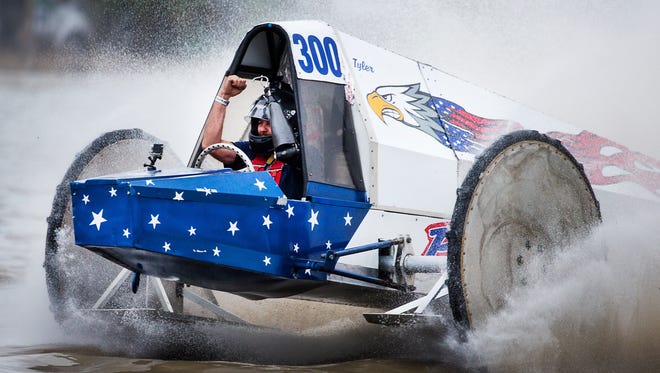 Tyler Johns throws his arms in the air as he crosses the finish line, winning the final race, during the Swamp Buggy Races Winter Classic in January at the Florida Sports Park.