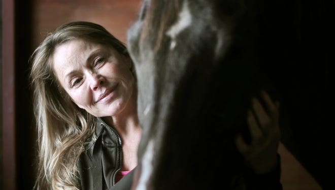 In a Dec. 5, 2017 photo, Tori Sue Olson scratches around the bridle of her horse, Flit the Leader, while inside the stable where she boards him near Palmyra, Wis. Olson, who overcame a cocaine addiction and the loss of a close, father-like friend, nursed her horse Leader back to health after a nearly career-ending pelvic injury to become a National Barrel Horse Association World Championships finalist.