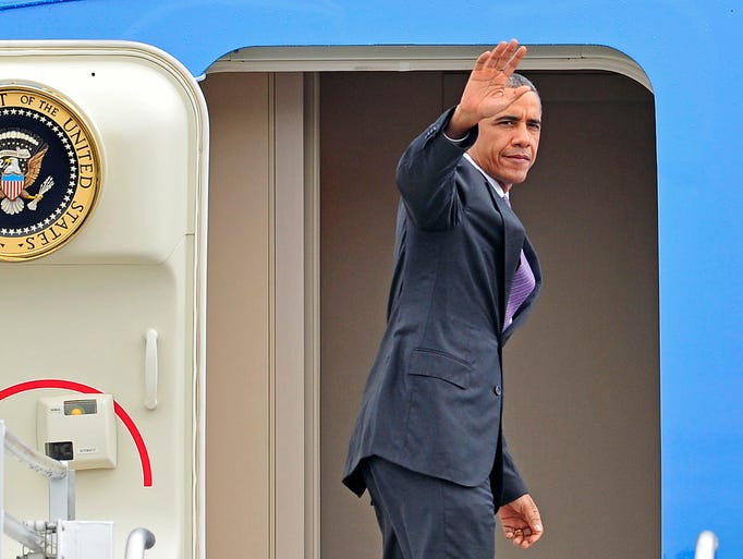 President Barack Obama waves as he boards Air Force