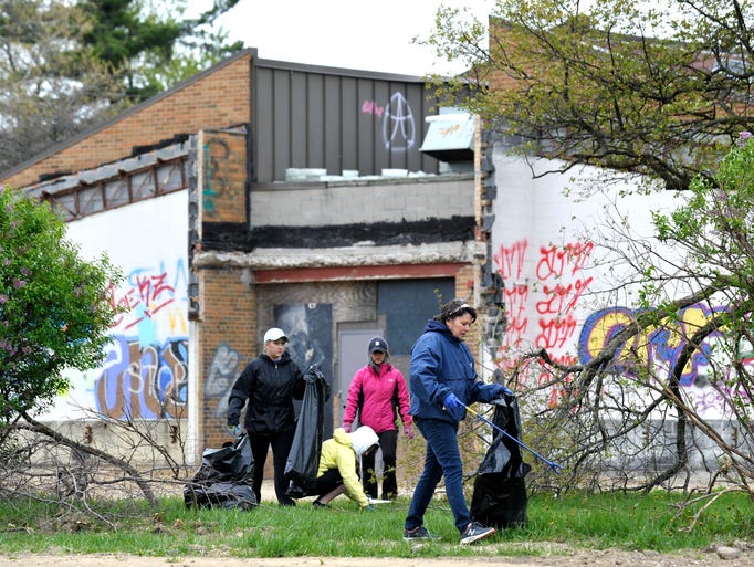 Alexis Maison, right, and others pick up debris near