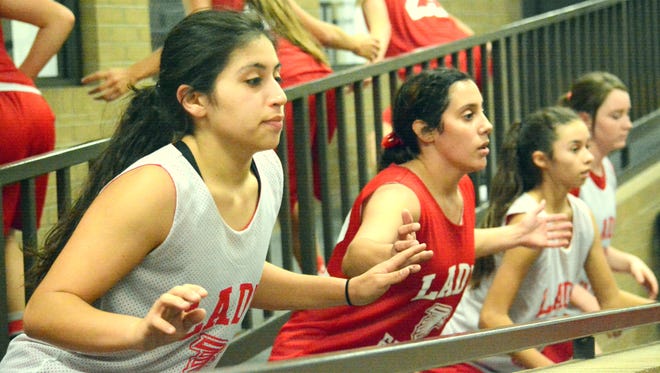 Loving's Cassandra Calderon (front left) and Alyssa Carrasco (front right) work on conditioning up and down the ramps entering the gym toward the end of Tuesday's practice. The Lady Falcons will play in the Goddard Holiday Classic tournament next Tuesday and Wednesday.