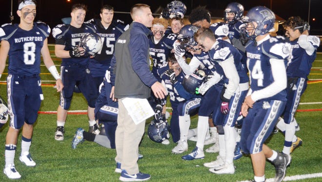 Rutherford's football team surrounding coach Andrew Howell after the North 2, Group 2 semifinal victory.