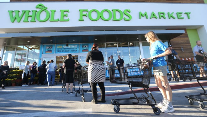 People waited to enter the new Whole Foods Market at 100 Pitt Wednesday morning. 