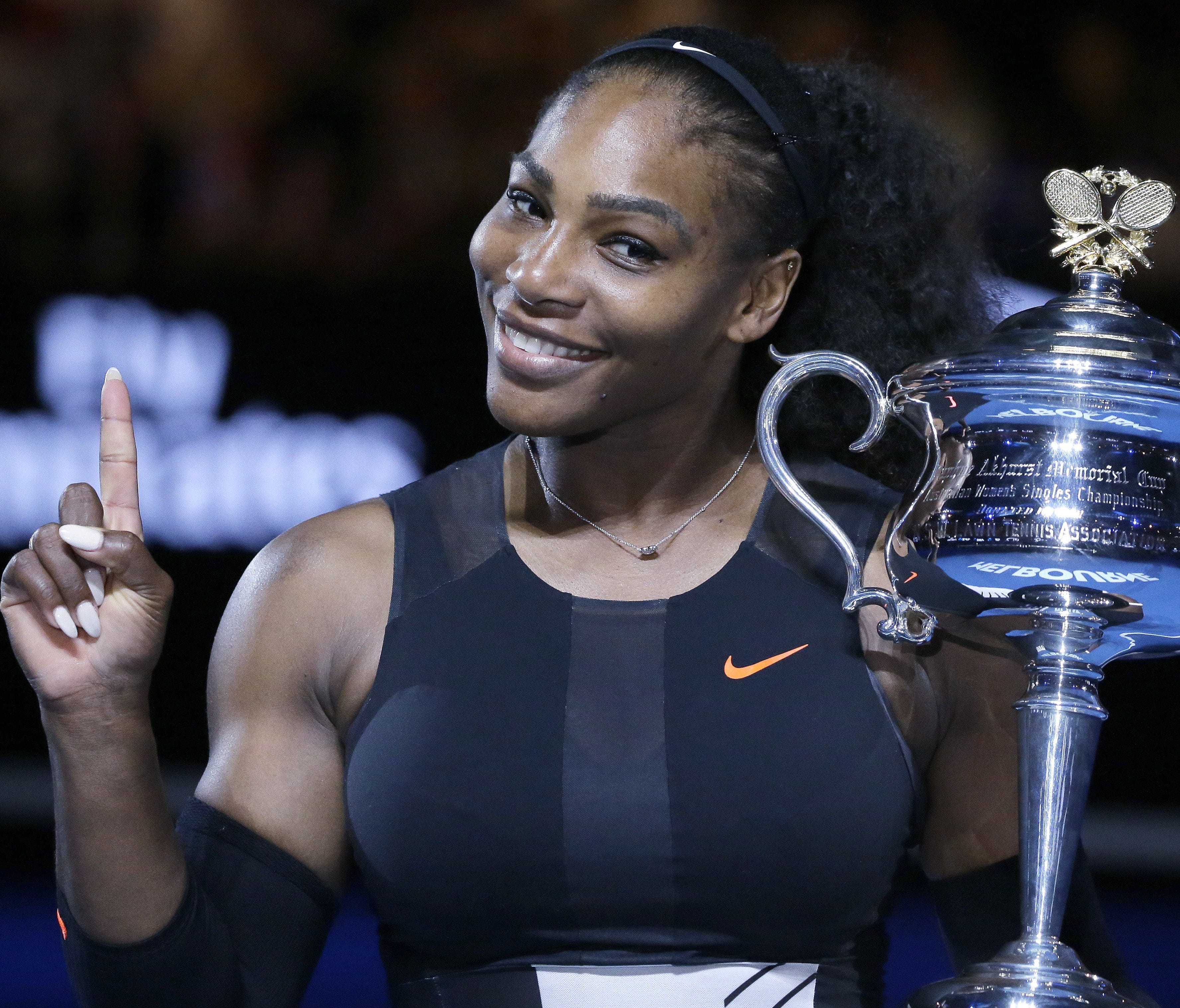 Serena Williams holds up a finger and her trophy after defeating her sister, Venus, in the women's singles final at the Australian Open tennis championships in Melbourne, Australia, on January 28.