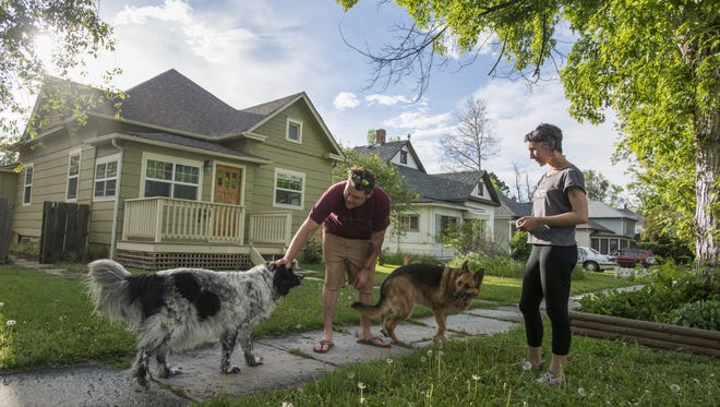 Whitney Johnson and Mark Maitland stand outside their home on Whedbee Street June 1 with their dogs Nina and Bender. The value for homes in the Old Town district have risen due to their desirable location in relation to downtown.