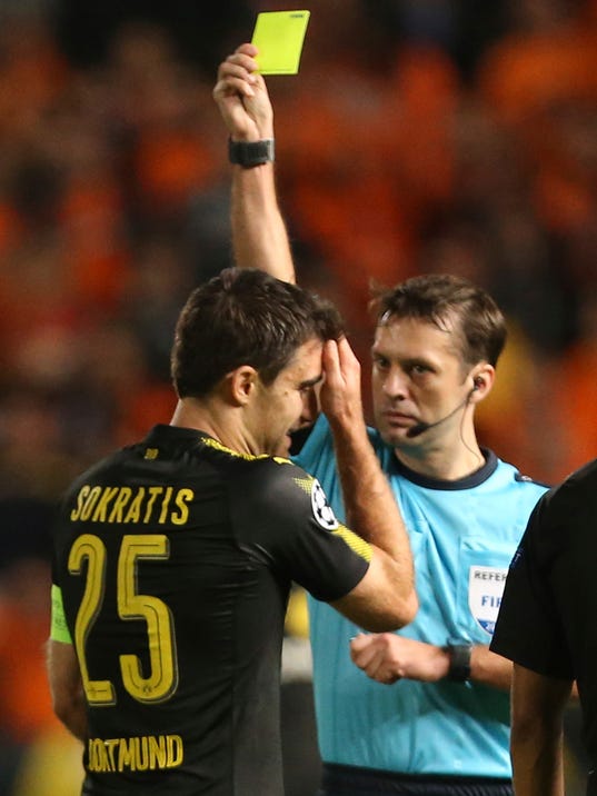 Dortmund's Sokratis is booked by referee Aleksei Kulbakov during the Champions League Group H soccer match between APOEL Nicosia and Borussia Dortmund at GSP stadium, in Nicosia, Cyprus, on Tuesday, Oct. 17, 2017. (AP Photo/Petros Karadjias)