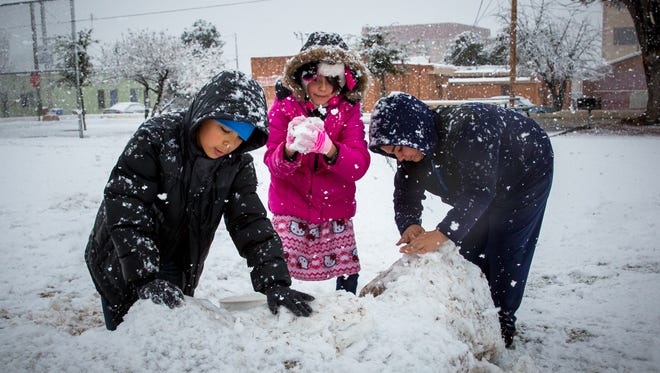 From left, Jesus Zamorano, 11, Jacqueline Zamorano, 12 and Joanna Hernandez, 17, build a snow fort at Klein Park in the Mesquite Historic District on Saturday afternoon. As much as 7 inches of snow is predicted to fall by this afternoon in Las Cruces.