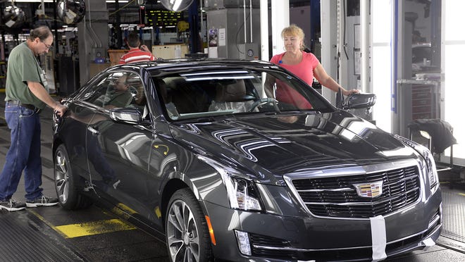 Cadillac ATS coupes are inspected at General Motors Co.’s Lansing Grand River assembly plant. GM is cutting the second shift at the Grand River plant in January.