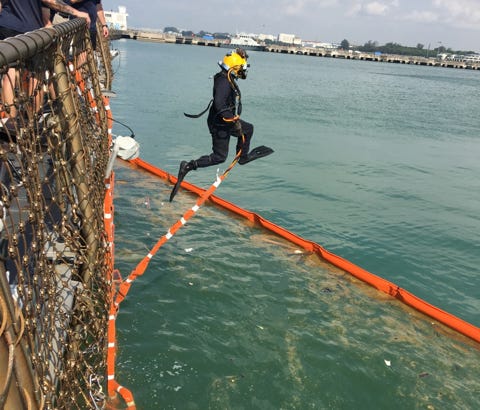 A Navy diver looks for sailors missing after the collision of the USS John S. McCain with a tanker near Singapore.