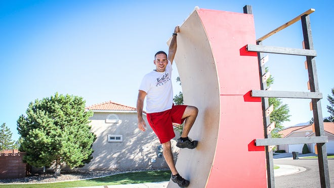 Josh Menendez hangs from a warp wall outside of his home in Cedar City.