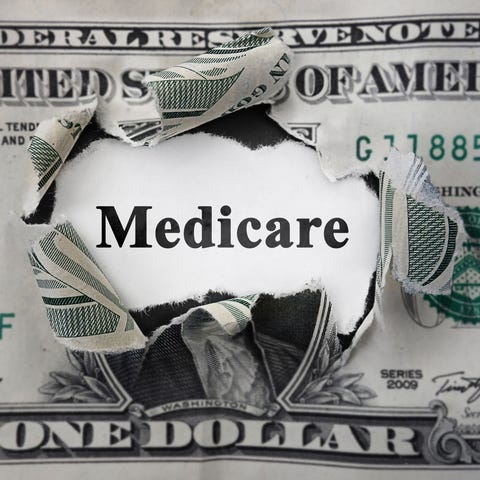 Torn one dollar bill with the word "Medicare" show
