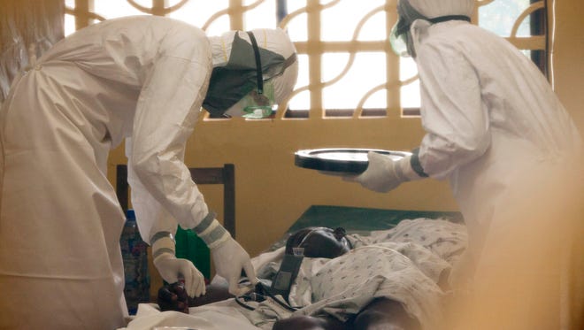 Physician Kent Brantly, left, treats an Ebola patient at the Samaritan's Purse Ebola Case Management Center in Monrovia, Liberia.