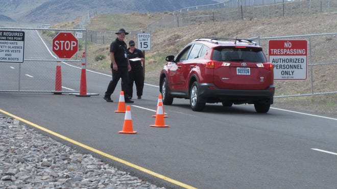 Security guards stop a car Friday Aug. 1, 2014, at the gate to the site Tahoe Reno Industrial Center about 15 miles east of Reno, Nevada where Tesla Motors has broken ground as one of the possible places to build a $5 billion "Giigafactory'' to make lithium batteries for its electric cars.