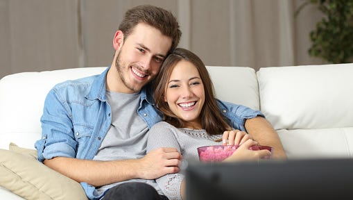 Happy couple watching movie on tv
