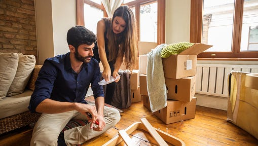 Couple Having Fun Moving In and Assembling Furniture