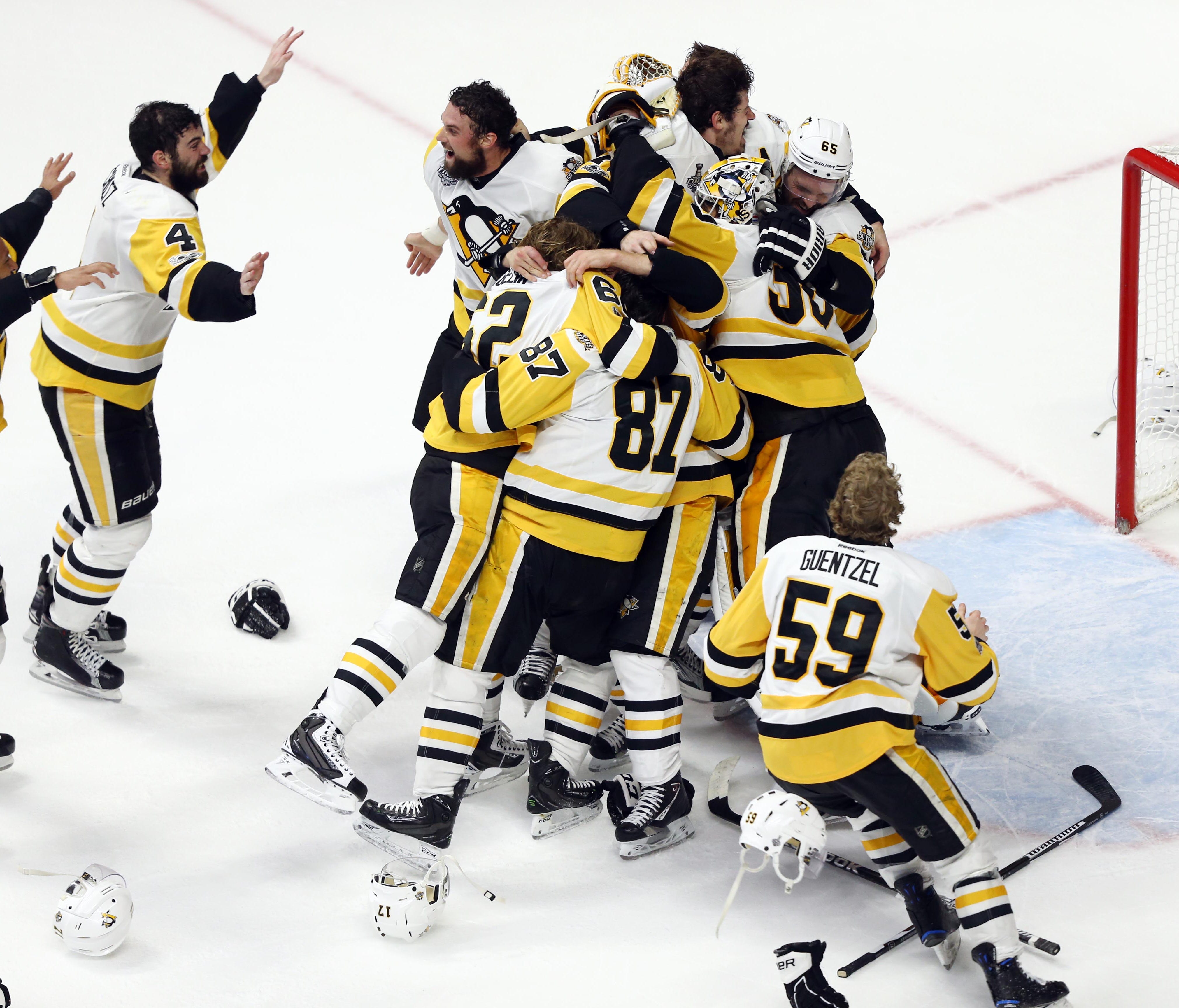 Pittsburgh Penguins players celebrate on the ice after defeating the Nashville Predators in Game 6 to clinch back-to-back Stanley Cup titles.