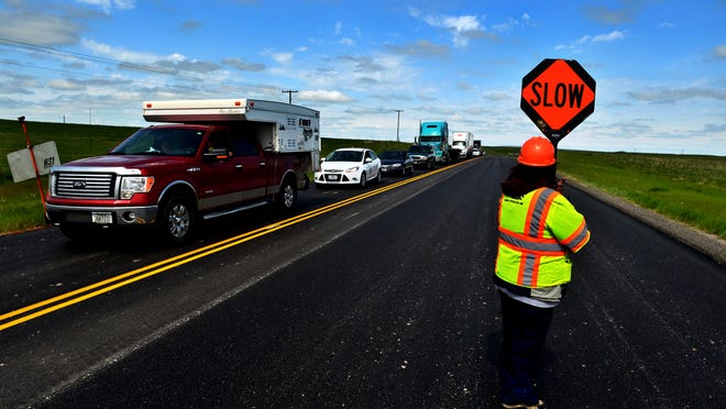 A line of cars waits for the pilot car to take them through the road construction zone on Highway 87 in 2014.