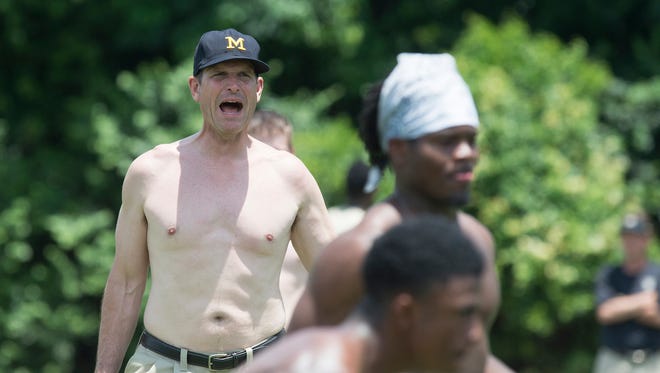 Michigan football coach Jim Harbaugh plays shirtless with participants during the Coach Jim Harbaugh's Elite Summer Football Camp, Friday, June 5, 2015, at Prattville High School in Prattville, Ala.