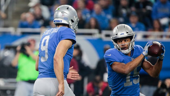 Lions quarterback Matthew Stafford, left, flips the ball to receiver Golden Tate in the second half against the Vikings on Nov. 23.