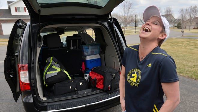 Jodi Gertken shares a laugh as she packs the family van Thursday for the trip to compete in the Boston Marathon.