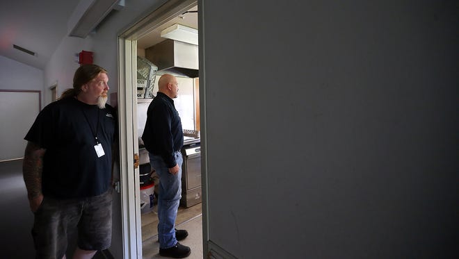 Kitsap Mental Health maintenance technician Dylan Diehl (left) looks into the kitchen where Damian Uzueta and others gather during a tour of what will be the Kitsap County Crisis Triage Center in East Bremerton on Thursday, July 20, 2017.