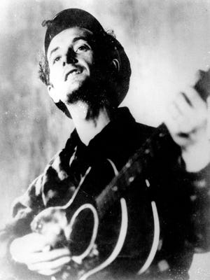 This undated file photo shows folk singer Woody Guthrie playing his guitar.
