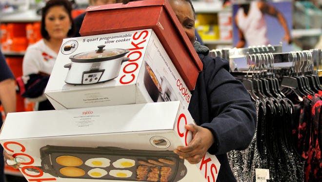 A shopper takes her purchases to the register during Black Friday sales in this 2012 file photo