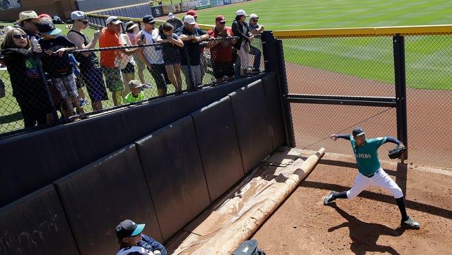 Fans watch as Seattle Mariners starting pitcher Felix Hernandez throws in the bullpen before a spring training baseball game between the Mariners and the San Diego Padres in Peoria, Arizona on Wednesday, March 30, 2016.