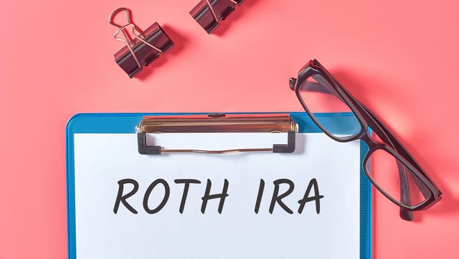 Roth IRA on clipboard with glasses.