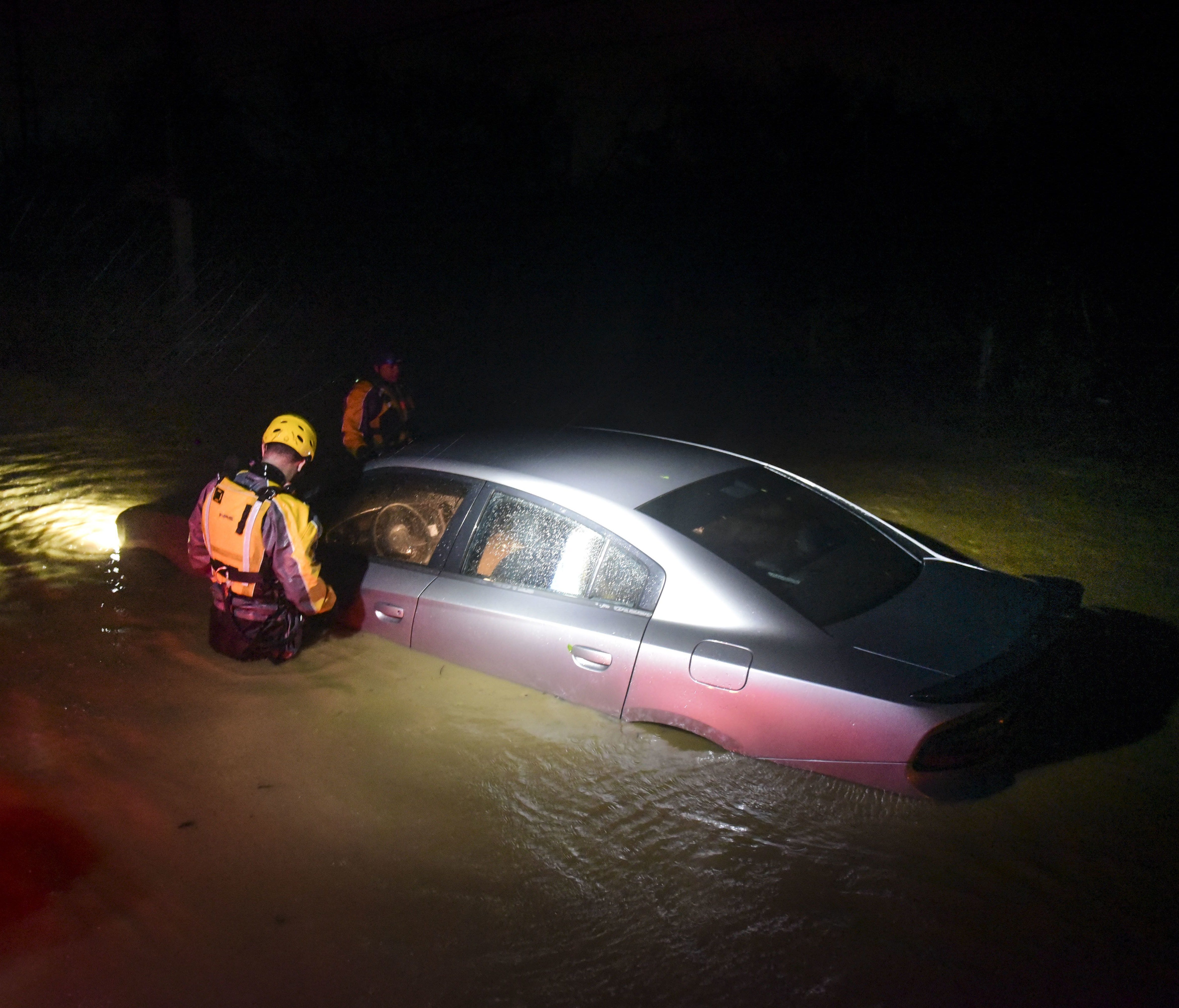 Rescue staff from the Municipal Emergency Management Agency investigate a flooded car during the passage of Hurricane Irma through the northeastern part of the island in Fajardo, Puerto Rico.