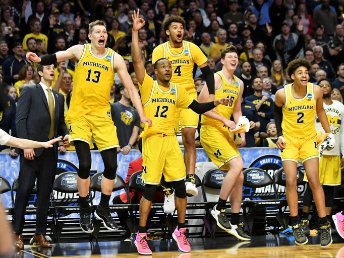 Players on the Michgan bench react after Michigan forward