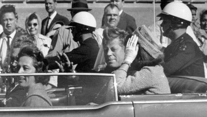 In this Nov. 22, 1963 file photo, President John F. Kennedy waves from his car in a motorcade in Dallas. Riding with Kennedy are First Lady Jacqueline Kennedy, right, Nellie Connally, second from left, and her husband, Texas Gov. John Connally, far left.