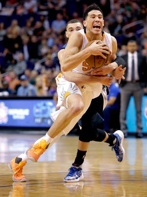 Phoenix Suns' Devin Booker, front, is fouled by Minnesota Timberwolves' Zach LaVine during the second half of an NBA basketball game, Monday, March 14, 2016, in Phoenix. The Suns won 107-104.