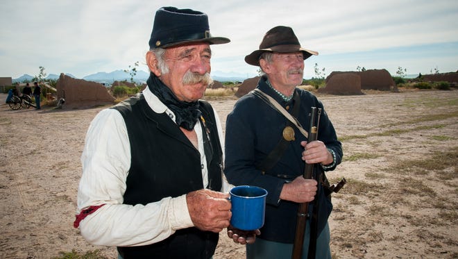 John Smith, left, who has been participating in historical reenactments since 1994, has a cup of coffee while standing next to another re-enactor at Fort Selden State Monument Frontier Day on Saturday.