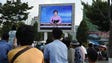 Residents look up at a big screen TV in front of Pyongyang
