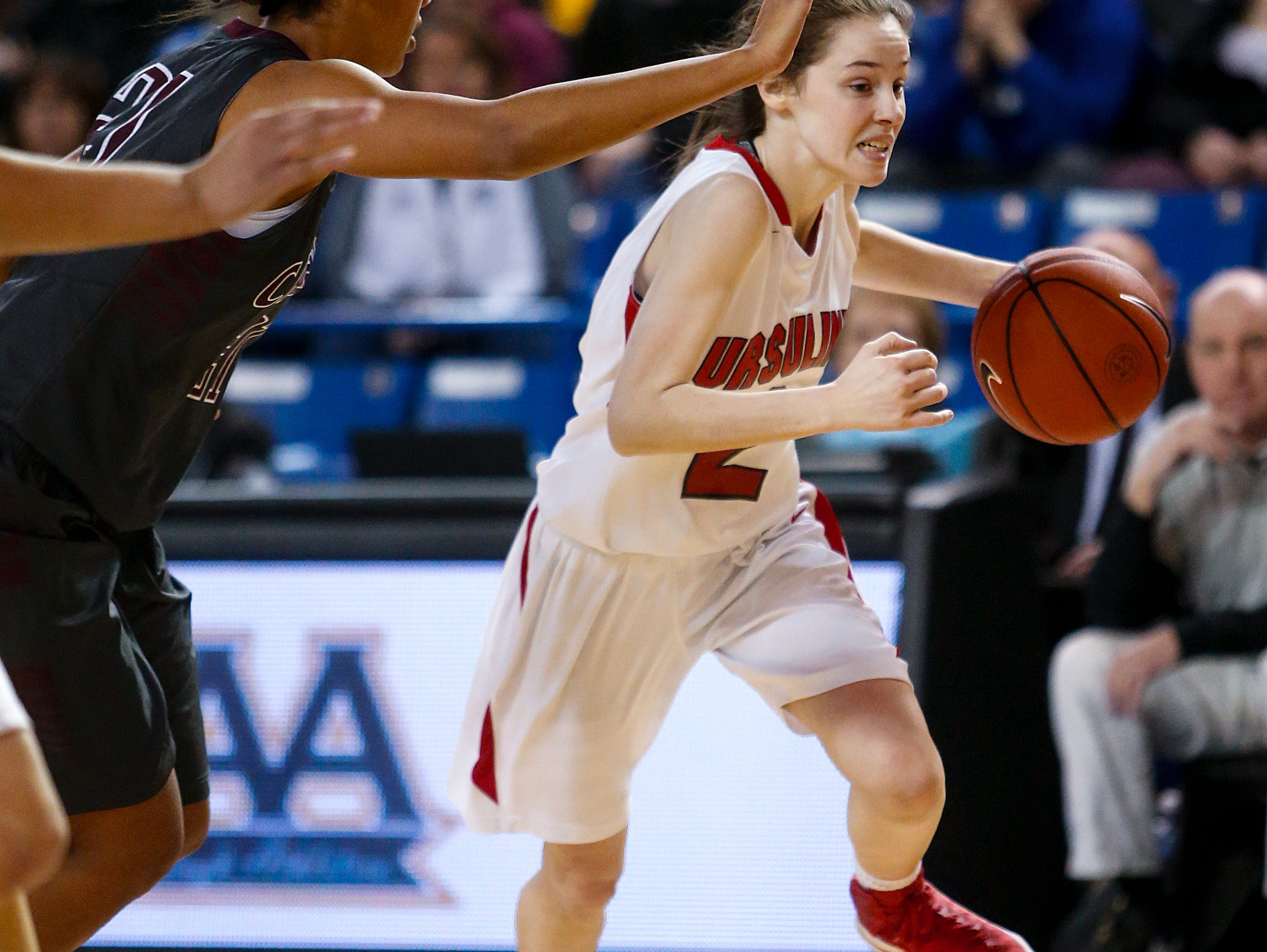 Ursuline's Maggie Connolly drives against Caravel's Kaylee Otlowski in the first half of the Raiders' 54-32 win in the DIAA state tournament title game at the Bob Carpenter Center Friday.