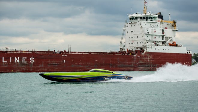 A powerboat passes the freighter CSL Welland during test runs for the St. Clair River Classic Offshore Boat Race Saturday, July 30, 2016 in St. Clair.