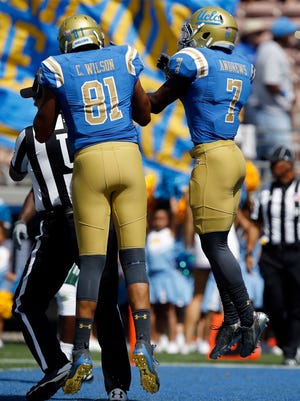 UCLA wide receiver Darren Andrews, right, leaps to celebrate his 25-yard touchdown catch with tight end Caleb Wilson, left, against Hawaii during the first half of an NCAA college football game in Pasadena, Calif., Saturday, Sept. 9, 2017. (AP Photo/Alex Gallardo)