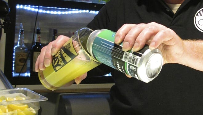 Bartender Rodney Shipp pours a can of "Alegae Bloom" beer at Maumee Bay Brewing Co. in Toledo, Ohio.