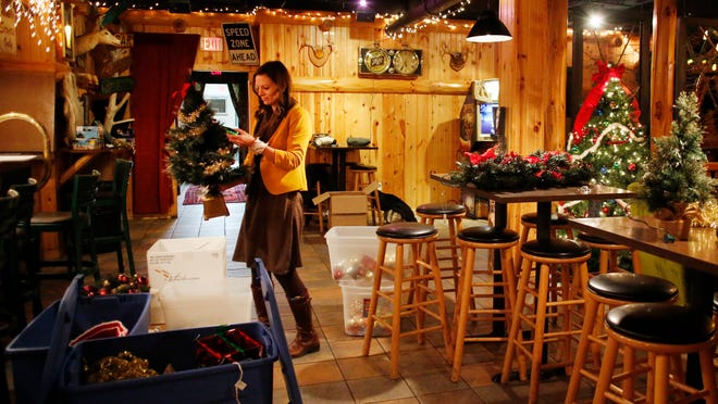 
Becky Kafka of Lemonaide Design Co. decorates the Leg Lamp Lodge for the holidays in advance of Tuesday’s opening of “A Christmas Story, the Musical” at the nearby Fox Cities Performing Arts Center. The bar is extending its hours in anticipation of visits from “Christmas Story” patrons.
