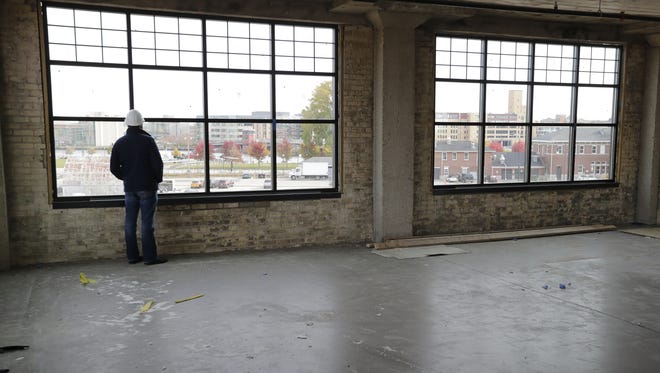 Jim Kratowicz, COO of Titletown Brewing Co., looks out one of the newly installed windows of the third floor office space being built at the former Larsen Green property.