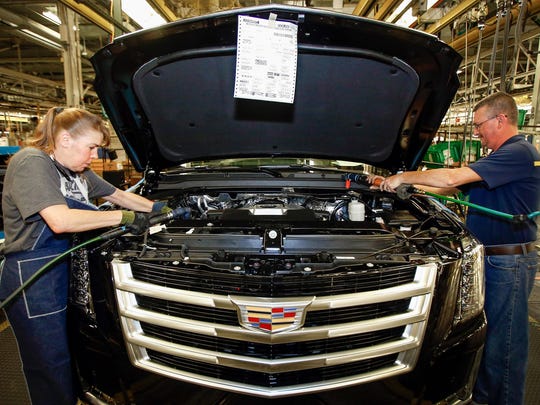 Karen Sparks (left) and John Johnson work on the assembly line at the General Motors Arlington Assembly Plant Tuesday, July 14, 2015.