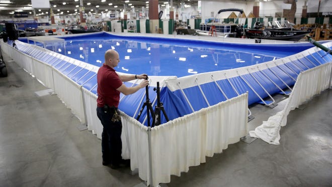 Caleb Miller, an electronic technician, sets up speaker stands outside Lake Milwaukee, the latest attraction at the 77th annual Milwaukee Journal Sentinel Sports Show. Lake Milwaukee will feature live fishing and boating demonstrations.