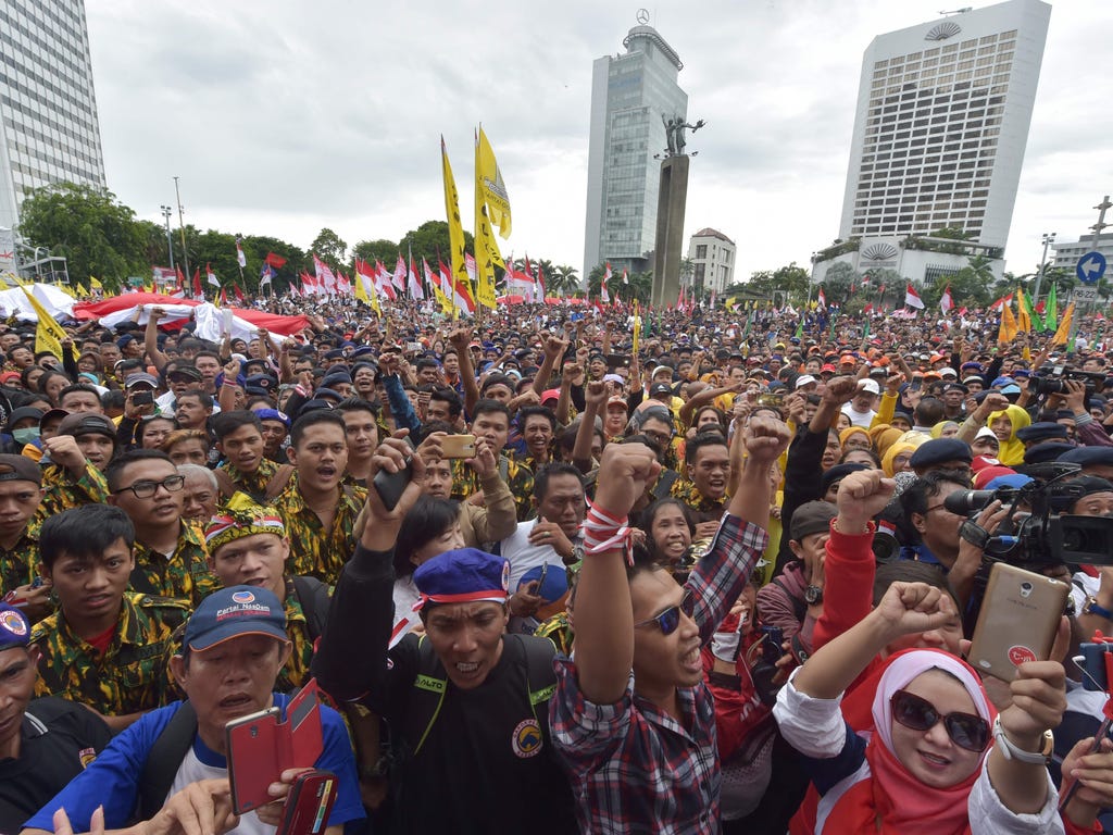 Indonesian people shout slogans as they attend a pro-government rally to call for unity in Jakarta. Thousands of people paraded in Indonesia's capital Jakarta to call for unity and peace amid growing tensions in the society.