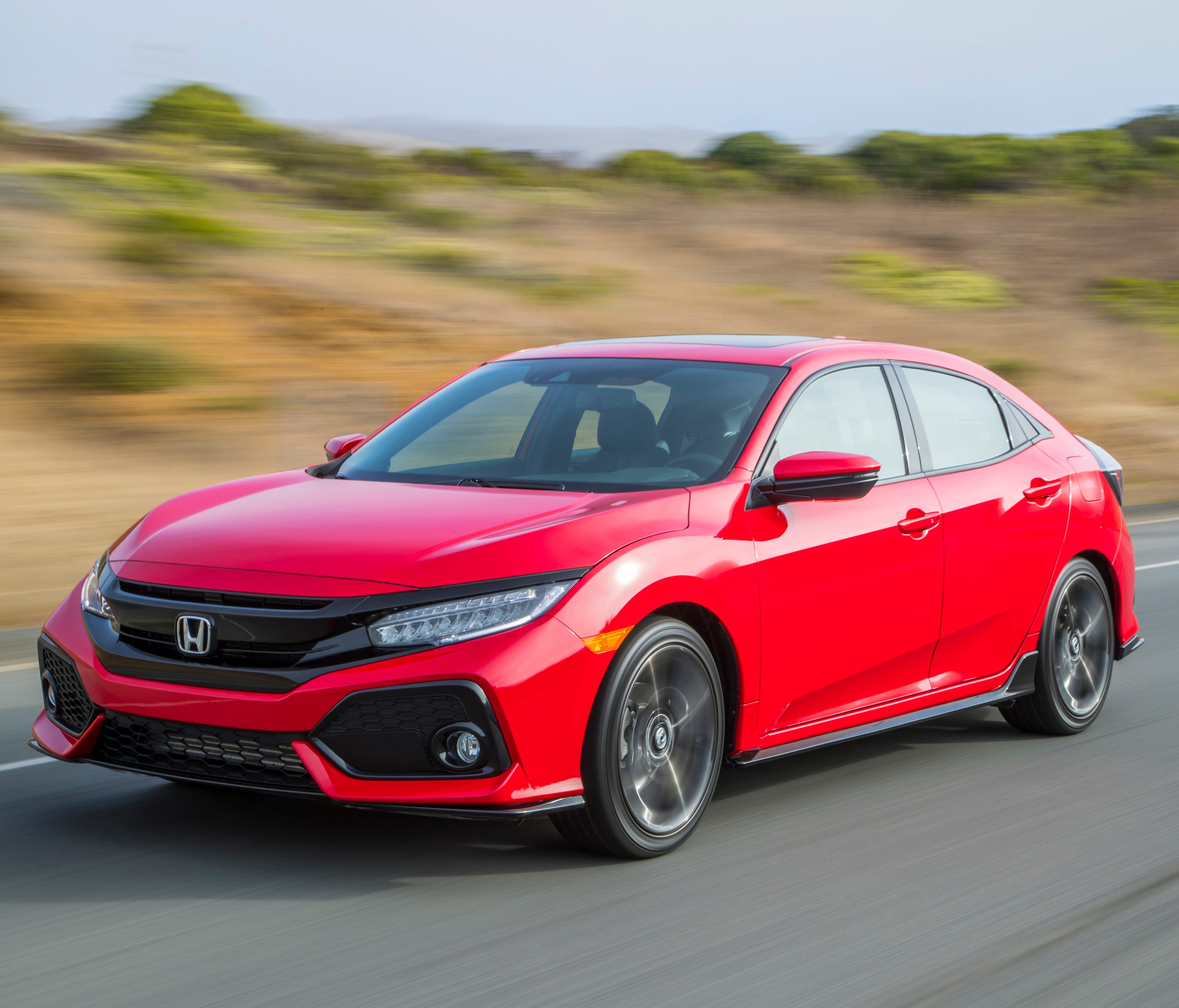 This photo provided by Honda shows the 2018 Honda Civic hatchback, a thoroughly competent compact that re-establishes Honda as a leader in this class, according to Edmunds. Compared to the rival Golf, it offers about 10 percent less cargo space, but 