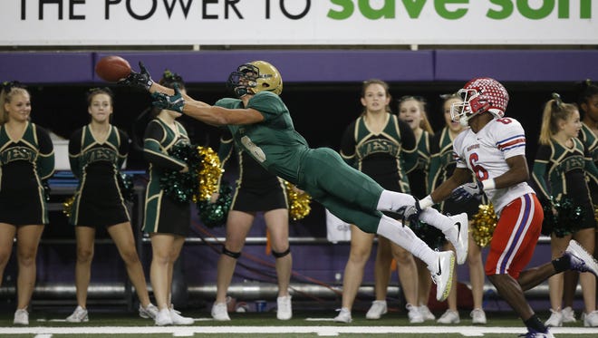 Iowa City West's Oliver Martin reaches for the ball as Cedar Rapids Washington's Ty Johnson defends Nov. 11, 2016, during the 4A state semifinal game at the UNI Dome in Cedar Falls.