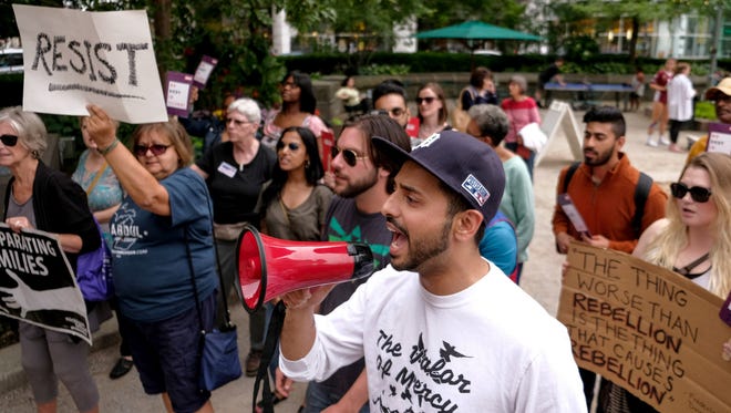 Hamtramck Community and Economic Development Coordinator Hassan Sheikh of West Bloomfield leads a group of people gathered at Campus Martius in downtown Detroit on Tuesday, June 26, 2018 in a chant while protesting the Supreme Court ruling that morning upholding the travel ban on travelers from several majority-Muslim nations by President Donald Trump's administration.