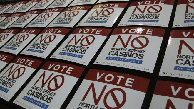 Stickers opposing a referendum on whether to allow two new casinos in northern New Jersey sit on a table before a rally in Atlantic City, N.J. on Thursday Oct. 27, 2016. The measure is designed to recapture gambling dollars being lost to casinos in neighboring states, but opponents say it could cause three of Atlantic City's seven casinos to shut down.(AP Photo/Wayne Parry)